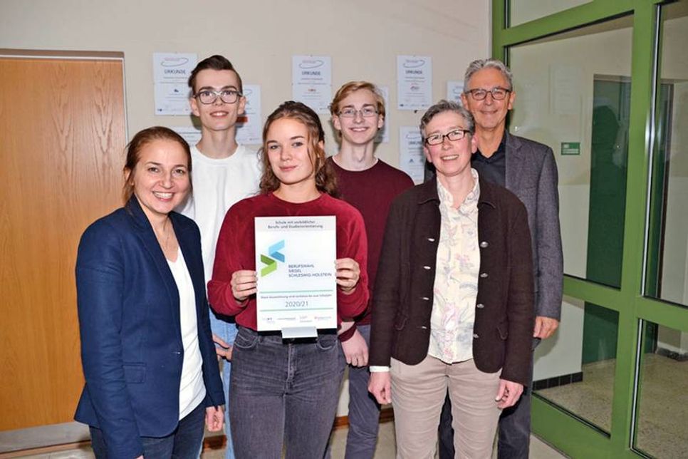 Sichtlich stolz auf das Berufswahl-Siegel des Landes Schleswig-Holsteins: Bürgermeisterin Hatice Kara (v.li.), Maximilian Bregovac, Lilian Bartsch, Colin Busch, BOS-Koordinatorin Meike Niehaus und OGT-Schulleiter Michael Bartolf. (Foto: René Kleinschmidt)