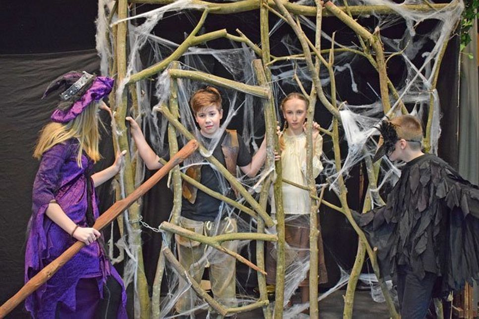 Eingesperrt und bewacht von der Hexe und der Krähe werden Hänsel und Gretel im Hexenhaus gefangen gehalten