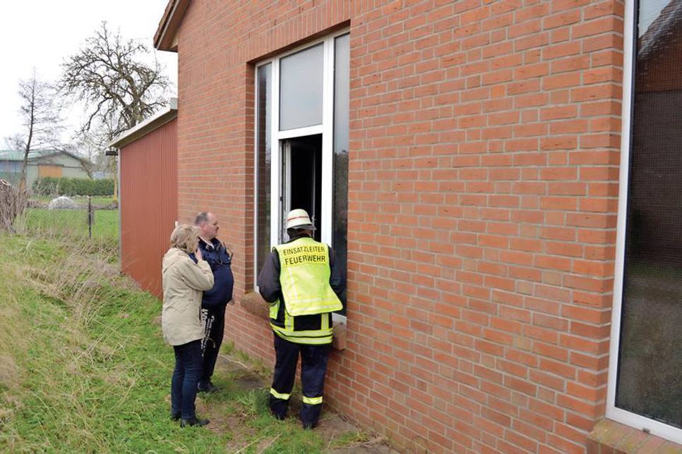 Durch ein Seitenfenster werfen Sven Asmußen (r.), Günter Volgmann und Brigitte Rahlf-Behrmann einen Blick in die stark verqualmte Fahrzeughalle. (Foto: Stefan Setje-Eilers)