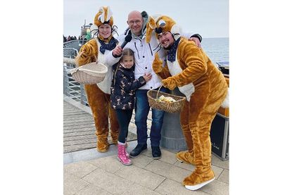 Die Osterhasen der TSNT GmbH und DJ René Kleinschmidt freuen sich beim Osterbuddeln an der Maritim-Seebrücke auf viele kleine und große Gäste.