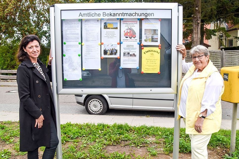 Dorfvorsteherin Regina Scharnweber (re.) bedankt sich bei Bauhofsleiterin Bettina Schäfer für das schnelle Aufstellen des neuen Schaukastens in Pönitz am See.