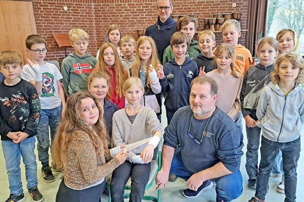 Die neunjährige Klara „verarztet“ Schulkameradin Mia. Die DRK-Ausbilder Sina Reese und Kai Beckmann sowie der Rest des Kurses schauen zu.