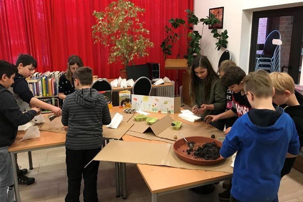 Die Kinder beim Wildblumensaatkugeln kneten.