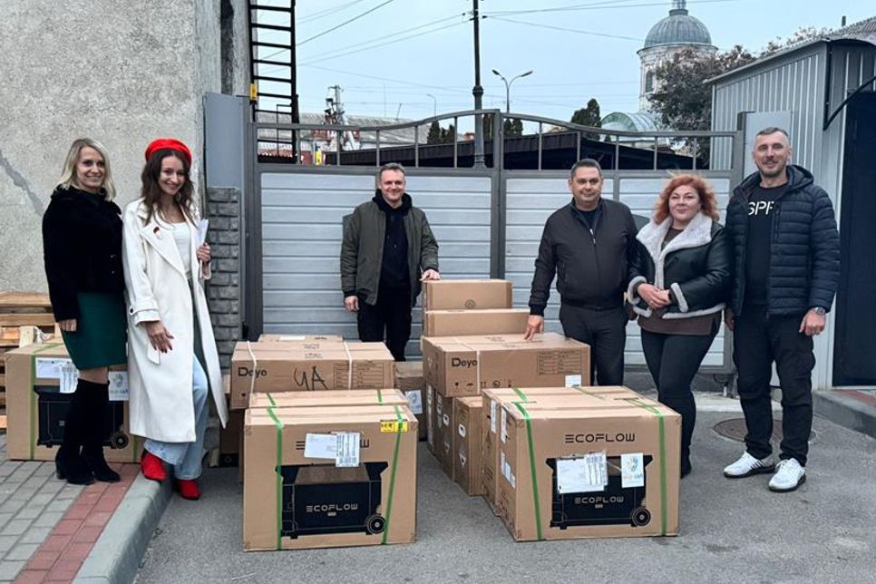 Übergabe der Batteriespeicher und Wechselrichter, die im Falle eines Stromausfalls, etwa aufgrund von Kriegshandlungen, einspringen und Teile von Gebäuden weiterhin mit Strom versorgen, sodass ein Blackout ausbleibt.