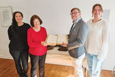 Manja Krausche, Leiterin der Gedenkstätte (von links), Ingaburgh Klatt, stv. Vorsitzende des Trägervereins der Gedenkstätte Ahrensbök, Timmendorfer Strands Bürgermeister Sven Partheil-Böhnke und die Timmendorfer Gemeindearchivarin Carmen Knickmeier bei der Übergabe der Reichsgesetzblätter in Ahrensbök.