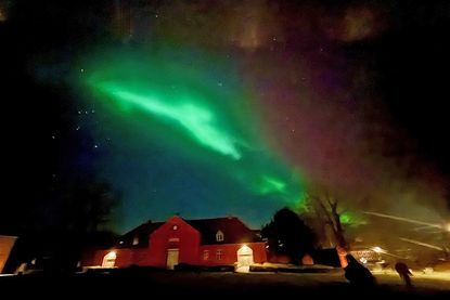 Das Polarlicht zeigt sich über dem Dach der Reithalle des Plöner Herzogs, dem alten „Uhrenhaus“, wie eine leuchtende Rauchfahne.