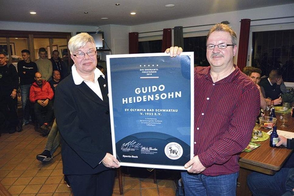 Als einer von landesweit elf Siegern ist Guido Heidensohn als vorgeschlagener Kandidat aus dem Kreisfußballverband Lübeck jetzt mit dem DFB-Ehrenamtspreis 2018 ausgezeichnet worden. Ulrike Harder vom zuständigen Ausschuss des SHFV sprach im Vereinsheim des SV Olympia Bad Schwartau die Laudatio und überreichte die Ehrenurkunde. (Foto: Stefan Setje-Eilers)