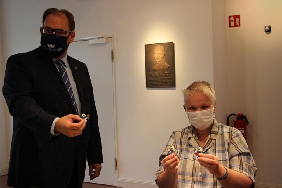 Bürgermeister Mirko Spieckermann überreichte der leidenschaftlichen Sammlerin Gaby Prüss bei der Ausstellungseröffnung einen Babyschlumpf aus dem eigenen Haushalt.