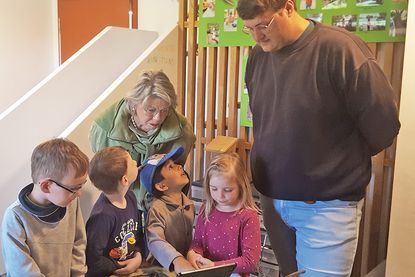 Die Kinder zeigen Dörte Cornils auf dem Tablet, wie man Vögel bestimmt.