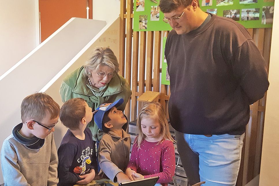 Die Kinder zeigen Dörte Cornils auf dem Tablet, wie man Vögel bestimmt.