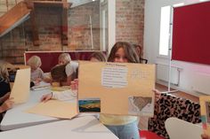 Schülerinnen und Schüler der Grundschule Neustädter Bucht präsentieren selbst gestaltete Plakate mit Bildern und kurzen Texten über Neustadt.