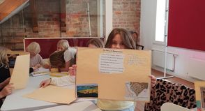 Schülerinnen und Schüler der Grundschule Neustädter Bucht präsentieren selbst gestaltete Plakate mit Bildern und kurzen Texten über Neustadt.