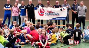 Verleihung des Banners „Aktiv im Kinderschutz“ an den VfR Laboe. Am Banner zu sehen sind (v.l.): Bernd Kiefer (Fußballjuniorenobmann im VfR), Carsten Bauer (Landessportverband), Michael Schnoor (erster Vorsitzender VfR), Heiko Voss (Bürgermeister) und Kay