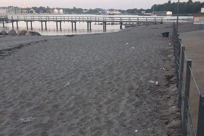 Glasflaschen im Sand beim Strandbad.