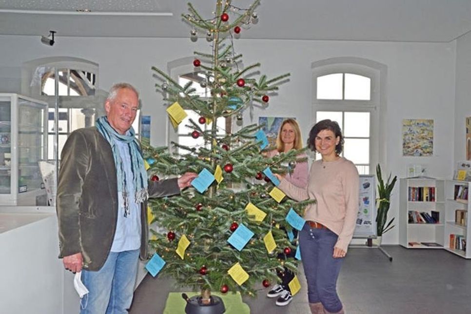 Stefan Thomsen, Vorstandsmitglied der Plöner Tafel, und die Mitarbeiterinnen der Tourist Info Cornelia Plagmann und Babette Otto (v. l.) als Unterstützer der Aktion hoffen auf spendenwillige Helfer, die für die Tafel-Kinder Weihnachtsgeschenke besorgen möchten – deren Wünsche finden sich am geschmückten Christbaum im Bistrobereich der Tourist Info im Plöner Bahnhof. Weitere Tafel-Wunschbäume gibt es in Lütjenburg, Ascheberg und Wankendorf, wo die Tafel ebenfalls aktiv ist.