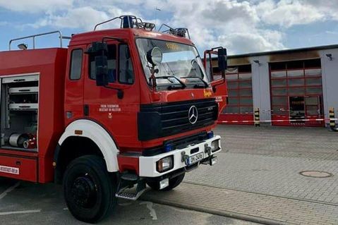 Fahrzeugübergabe in Oldenburg vor dem beschädigten Feuerwehrgerätehaus.