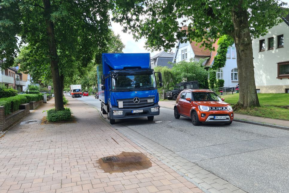 Zwei LKW liefern Produkte an die Einwohner und halten hier, während sie vom Verkehr überholt werden. „Wo soll hier sicheres Radfahren auf der Straße möglich sein?“, fragt Lück-Langer.