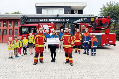 Carolin Dreismann, Präsidentin des Lions Club Lübecker Bucht, überreicht einen Scheck in Höhe von 4.000 Euro an Bo Anderson (vorne rechts) und David Siegmund für die Kinder- und Jugendfeuerwehr Scharbeutz.