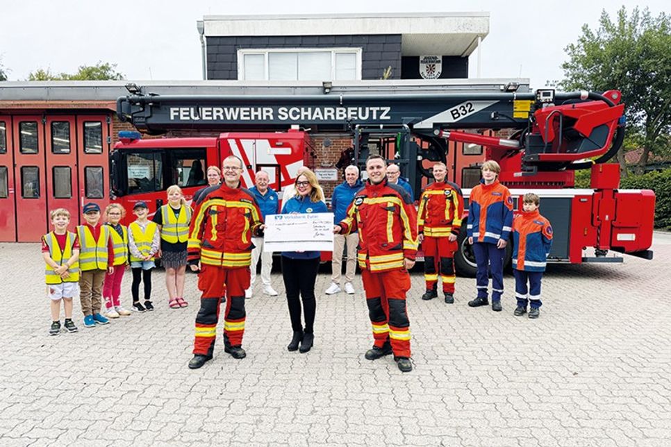 Carolin Dreismann, Präsidentin des Lions Club Lübecker Bucht, überreicht einen Scheck in Höhe von 4.000 Euro an Bo Anderson (vorne rechts) und David Siegmund für die Kinder- und Jugendfeuerwehr Scharbeutz.