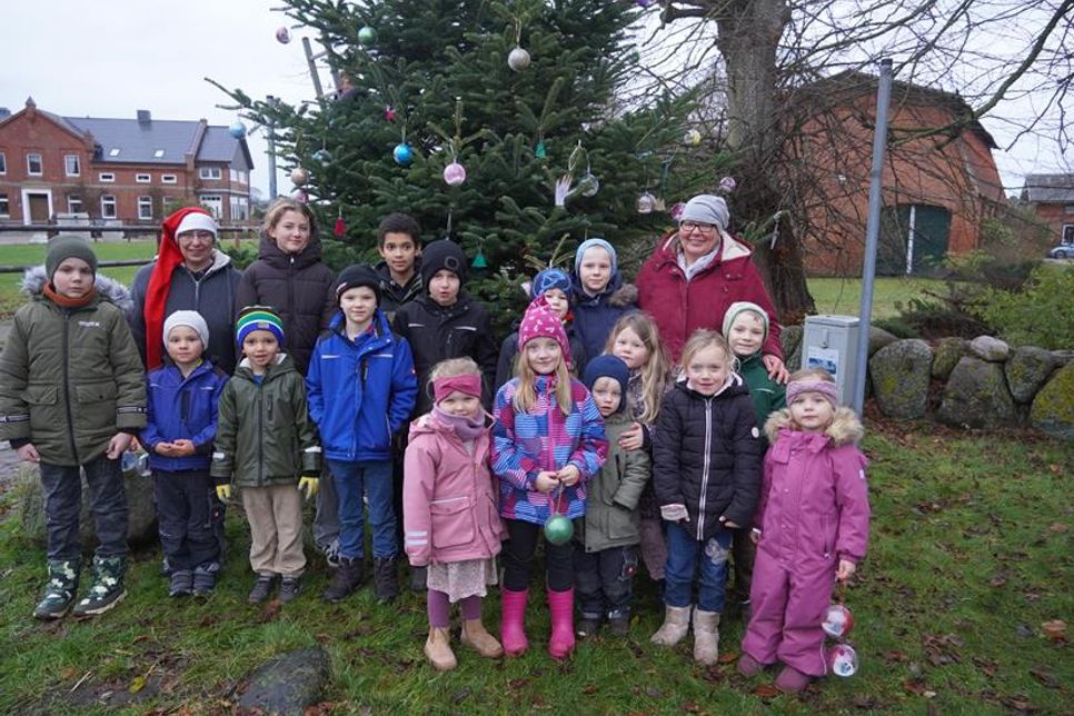 Kinder und Organisatorinnen beim Schmücken des Baumes.