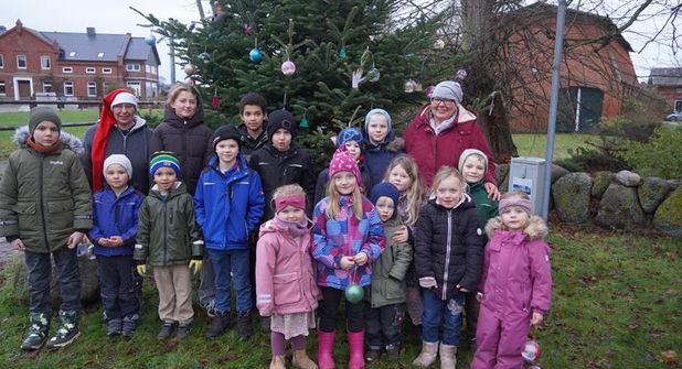 Kinder und Organisatorinnen beim Schmücken des Baumes.