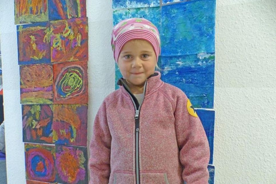 Romy, die hier direkt vor ihrem Luft-Bild steht und es sehr schön an der Wand des Gemeindebüros findet.