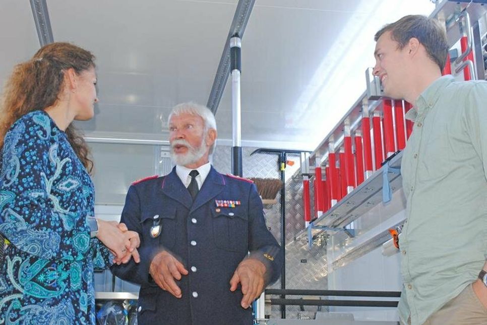 Amtsdirektorin Juliane Bohrer und der Kreistagsabgeordnete für Schönkirchen, Till Unger, hören interessiert zu im geräumigen Gerätewagen Logistik, während Ernst-Peter Schütt (Mitte) von seinen umfangreichen Erfahrungen über die Veränderungen bei der Feuerwehrtechnik erzählt.