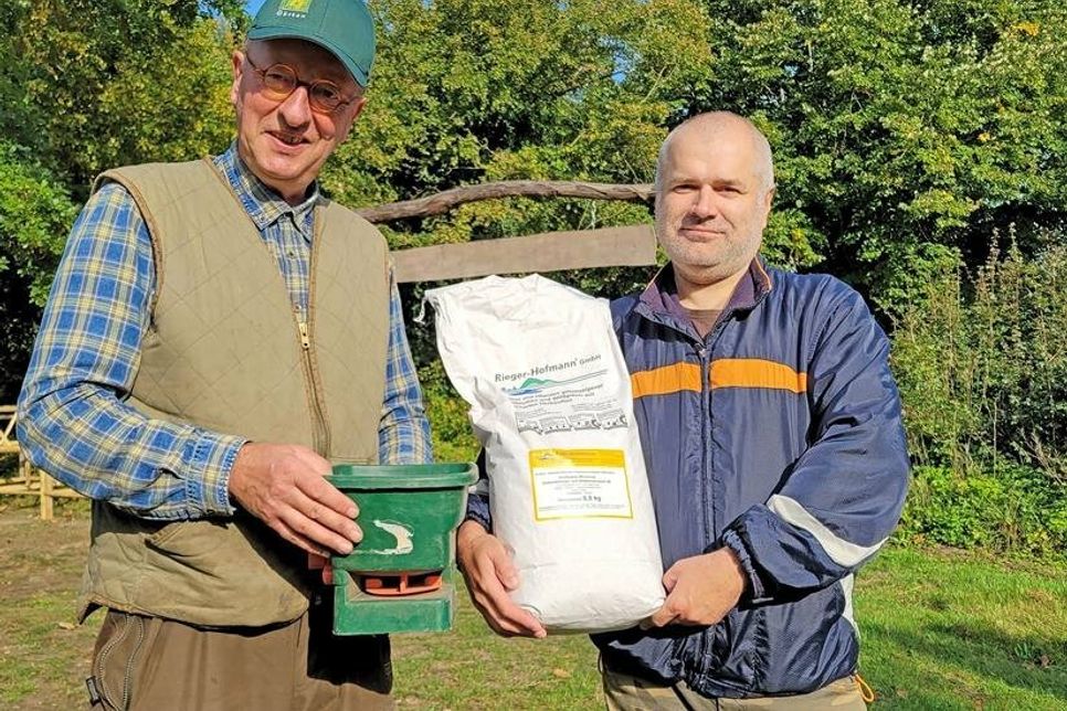 Jan Eskildsen (links) und Imker Eugenij Kozlow präsentieren die Saat für heimische Wildblumen und Wildgräser