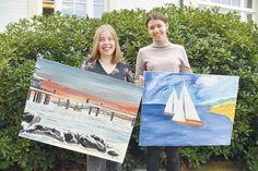 Projektleiterin Lena Schwarz-Priegnitz und Praktikantin Cara Westphal (rechts) präsentieren zwei Kunstwerke, die für den guten Zweck versteigert werden.