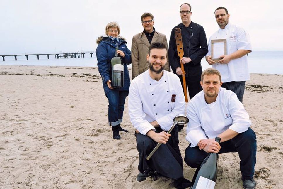 Martina Block und Joachim Nitz (hinten, 2.v.l.) von der Timmendorfer Strand Niendorf Tourismus GmbH freuen sich mit den Köchen Philipp Tiesel (hinten 2.v.r), Mirko Stäudel (hinten, r.) sowie Dennis Glauche (vorne, l.) und Florian Hannemann auf das diesjährige Beach Xining-Wochenende. (Foto: Stefan Setje-Eilers)