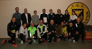 Mit dem frischgebackenen „Moin! Vereinsheld des Monats Januar“ Peter Massny (stehend Mitte, mit Urkunde) freuen sich Wiebke Watzlawek (Stiftungen der Sparkasse Holstein), Fabian Wierichs (Sparkasse Holstein, beide links vom Geehrten), Birgit Kamrath-Beyer (KSV Ostholstein) und Anett Virsnitis (TSV Neustadt, beide rechts vom Geehrten) sowie das Laufteam des TSV Neustadt. (Foto: Carsten Stender, Kreissportverband Ostholstein)