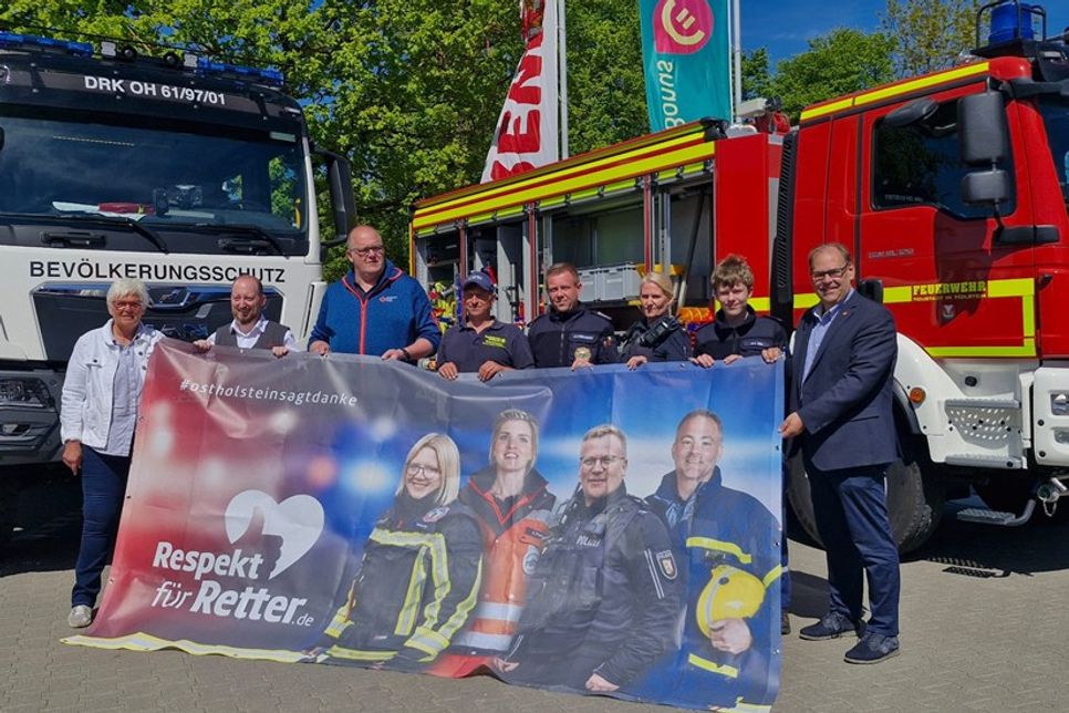 Übergabe des Banners der Kampagne „Respekt für Retter“ durch Kreispräsidentin Petra Kirner (lks.) und Bürgermeister Mirko Spieckermann (re.) an Benjamin Haase (2. v. lks.).