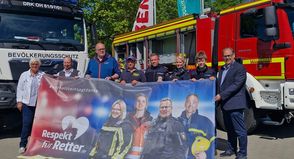 Übergabe des Banners der Kampagne „Respekt für Retter“ durch Kreispräsidentin Petra Kirner (lks.) und Bürgermeister Mirko Spieckermann (re.) an Benjamin Haase (2. v. lks.).