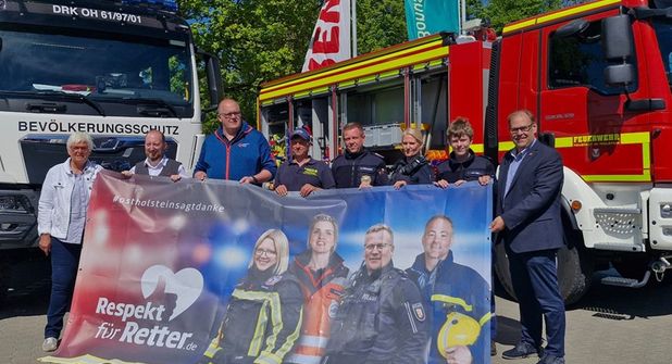 Übergabe des Banners der Kampagne „Respekt für Retter“ durch Kreispräsidentin Petra Kirner (lks.) und Bürgermeister Mirko Spieckermann (re.) an Benjamin Haase (2. v. lks.).