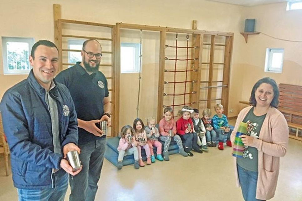 Bechertausch im Probsteier Kinderhaus: (V. r.) Kitaleiterin Nicole Bauer hat den Round Tablern Ron Matthießen und Präsidiumsmitglied Dennis Stahn die ausgedienten Plastikbecher für ein Recyclingprojekt mit auf den Weg gegeben.