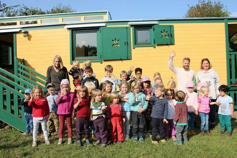 Die Naturgruppe mit ihren Betreuern vor dem schicken Bauwagen.
