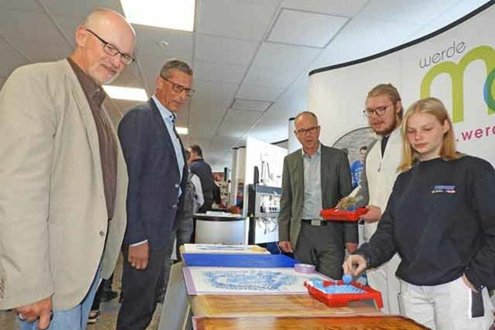 Bereichsleiter Thomas Vetter, Agenturleiter Markus Dusch und Schulleiter Christoph Salewski am Stand der Maler*innenklasse.