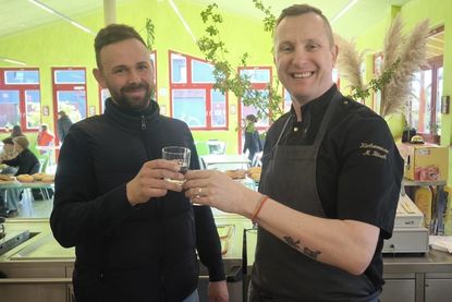Anstoßen mit frischem Wasser: Koch Mario Büsch (re.) freute sich über die großzügige Spende von Ronny Conrad.