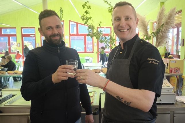 Anstoßen mit frischem Wasser: Koch Mario Büsch (re.) freute sich über die großzügige Spende von Ronny Conrad.
