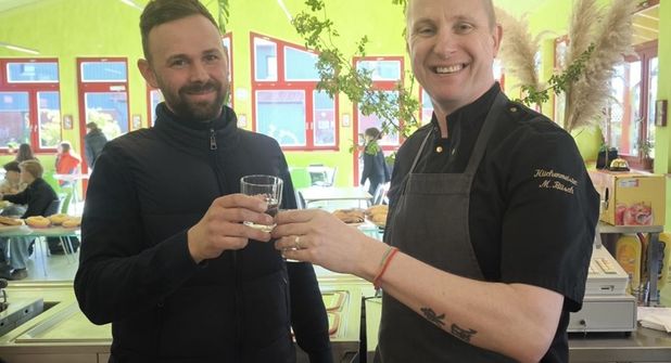 Anstoßen mit frischem Wasser: Koch Mario Büsch (re.) freute sich über die großzügige Spende von Ronny Conrad.
