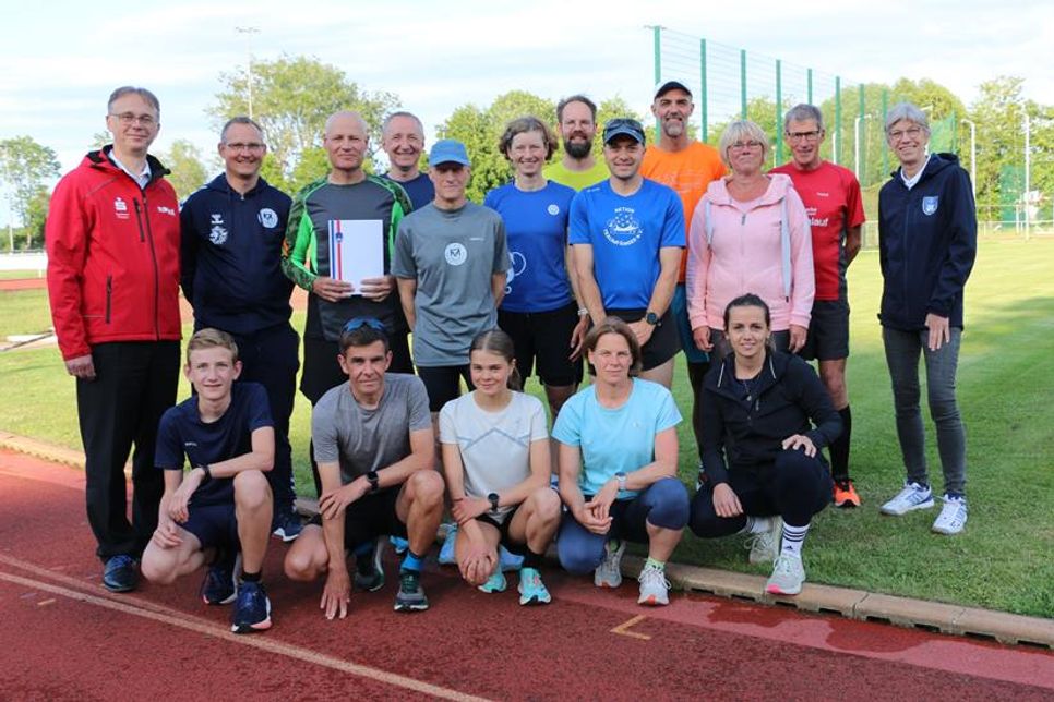 Der frischgebackene „Moin! Vereinsheld des Monats Juni“ Andreas Boller (TSV Neustadt, stehend 3. v. lks.) mit Karsten Wittorf (Sparkasse Holstein, stehend lks.), Jens Seemann (TSV Neustadt, stehend 2. v. lks.), Anett Virsnitis (TSV Neustadt, stehend 3. v. re.) und Birgit Kamrath-Beyer (KSV Ostholstein, stehend re.) sowie seinen „Lionsrunnern“ aus der Leichtathletik-Abteilung des TSV Neustadt.