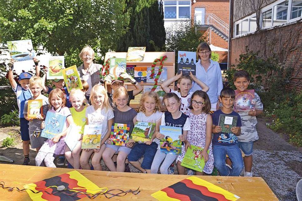 Lesestoff für die ersten Klassen: Übergabe des ersten Bücherregals durch Barbara Bergmann (Kinderherz e.V.) an die Klasse 1a und Klassenlehrerin Heike zum Felde (rechts). (Foto: René Kleinschmidt)