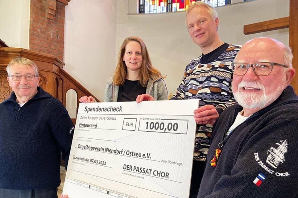 Symbolische Scheckübergabe in der Petri-Kirche (von links):  Rainer John (Passat Chor), Kirchenmusikerin Lena Sonntag, Peter Kleinschmidt vom Orgelbauverein und Jonny Holm (Passat Chor).