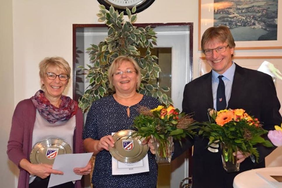 Bürgermeister Kai Johanssen nutzte den Rahmen der Veranstaltung für die Ehrung der „Gildehus-Frauen“ Manuela Rath und Carola Schwab (l.), die das Gemeindeleben in vielfältiger Weise unterstützt haben: Nicht nur durch die Bewirtung im Gildehus, sondern auch bei den Vorbereitungen des Gildefestes, zu denen unter anderem die Organisation von Geschenken für die Kinder (2018 waren es 150) sowie Haussammlungen (Spenden) zählen.