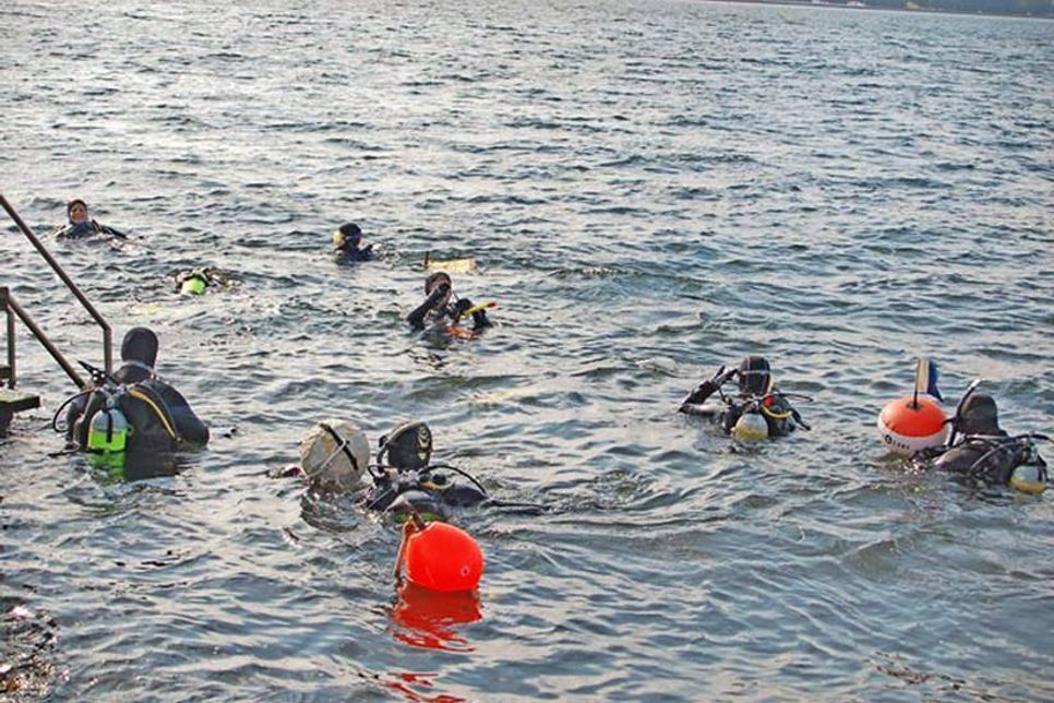 Taucher machen sich am Anleger von Mönkeberg startklar zum Müllsammeln unter Wasser.