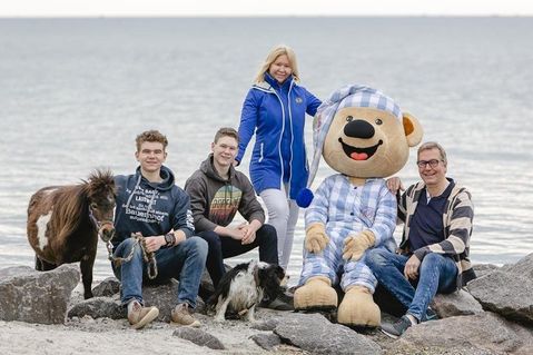 Bauer Martin Bendfeldt (re.) freut sich gemeinsam mit seiner Familie und Maskottchen „Baumi“ über die Auszeichnung.