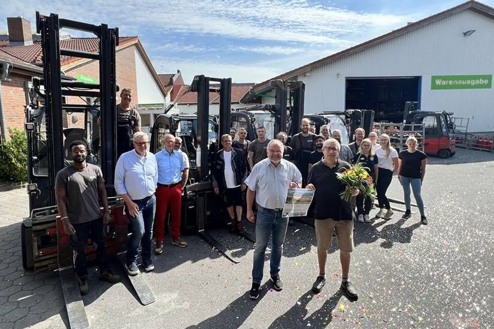 Marktleiter Holger Werner (vorne lks.) und die Kollegen aus Markt und Lager überreichten Meinhard Schuldt zum Abschied Blumen und Geschenke und ließen ihn hochleben.