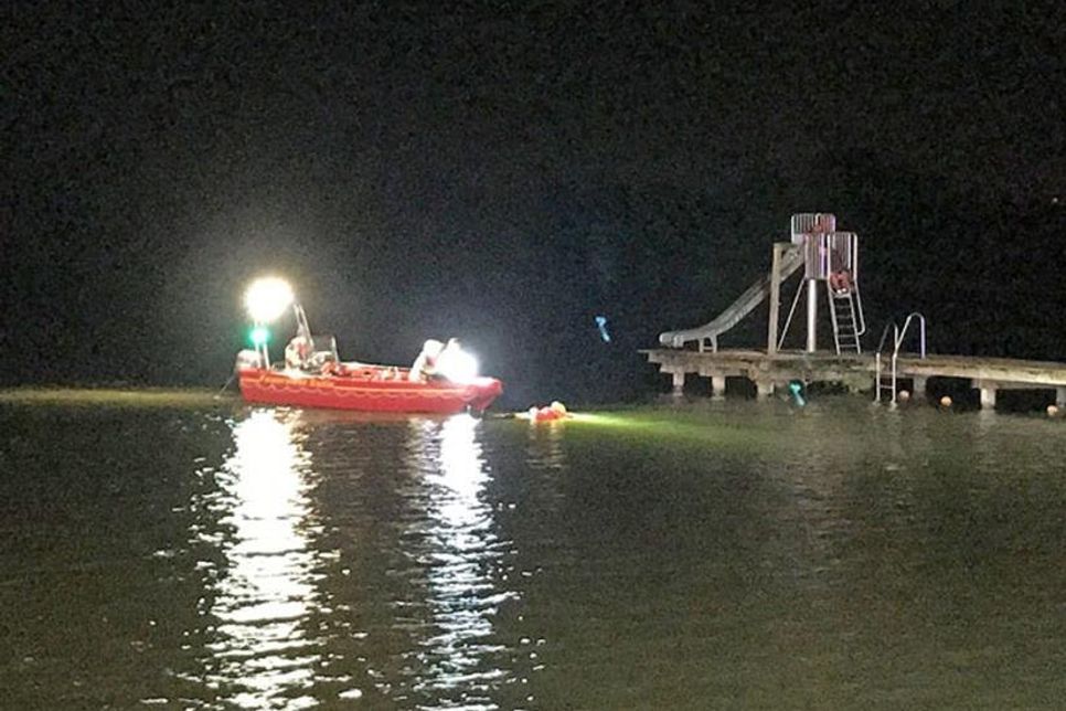 Im Wasser treibt regungslos ein Mann und wird vom Boot aus gerettet.
