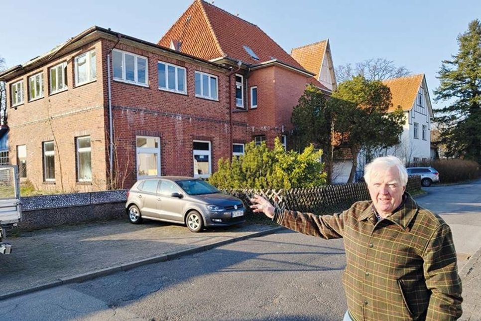 Bauausschuss-Vorsitzender Dieter Boeden zeigt im Barkholtredder auf einen Teil der leerstehenden Gebäuden, die für das neue Wohnprojekt weichen werden.