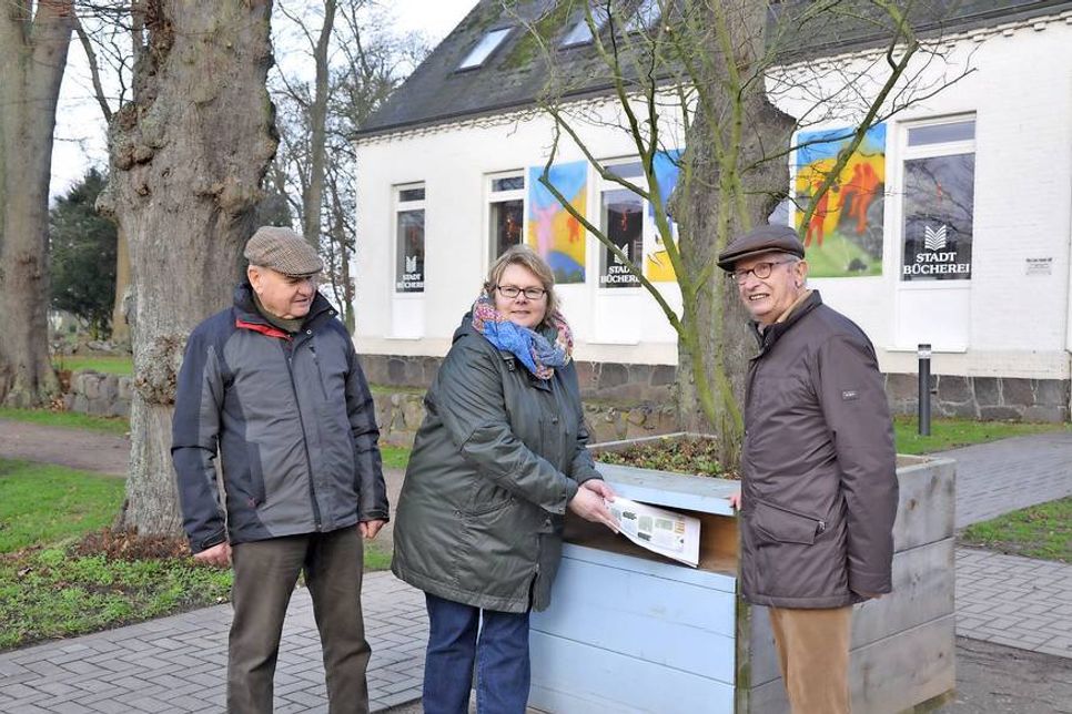 Willi Franck, Claudia Czellnik und Eberhard Toillé vom Ernst Ludwig Kirchner Verein Fehmarn e.V. vor dem Pflanzkübel mit der Kupfer-Felsenbirne.